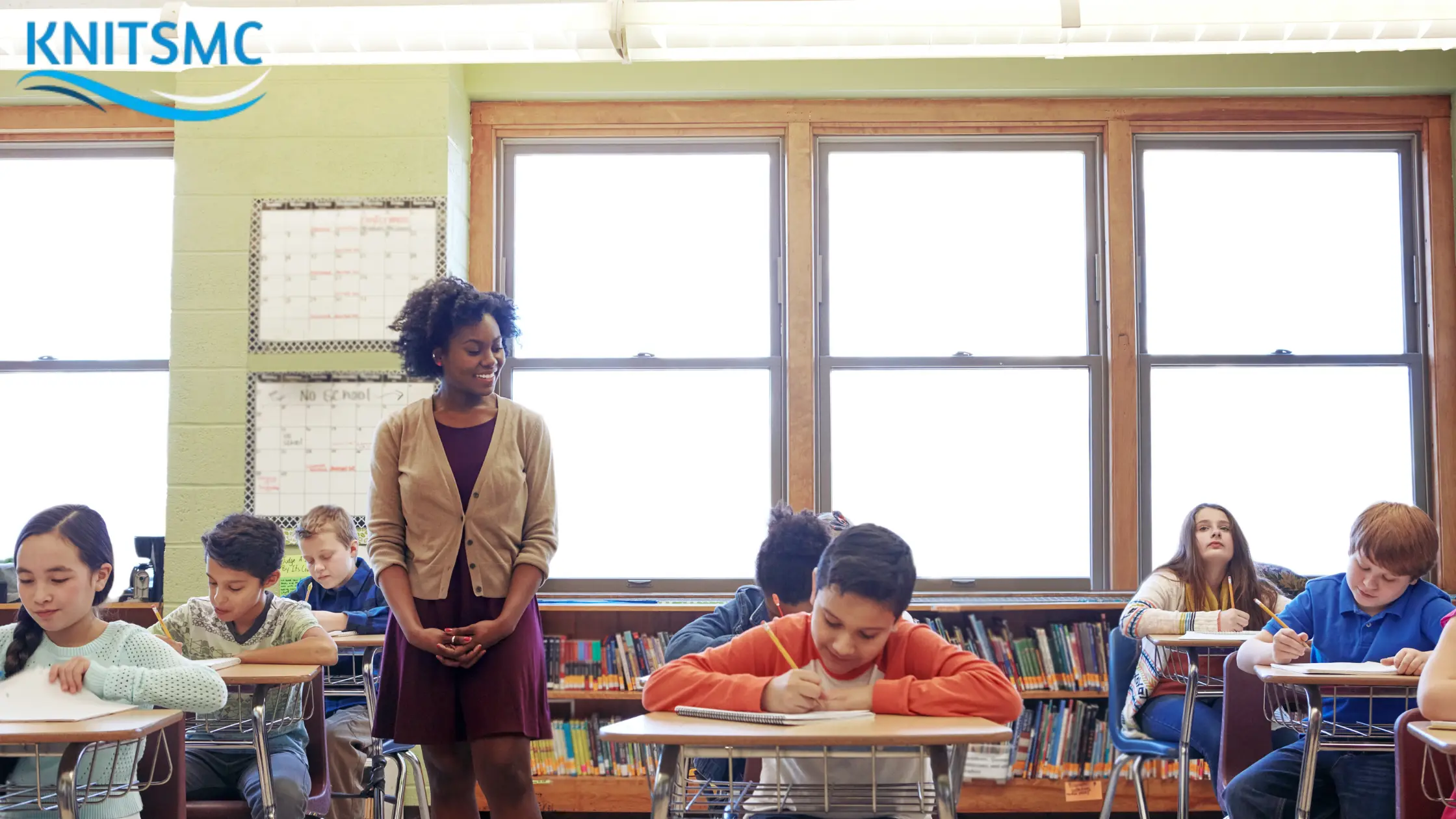 A classroom scene with a teacher observing students engaged in their work, illustrating the principles of Chapter Six Education Progressive methods.